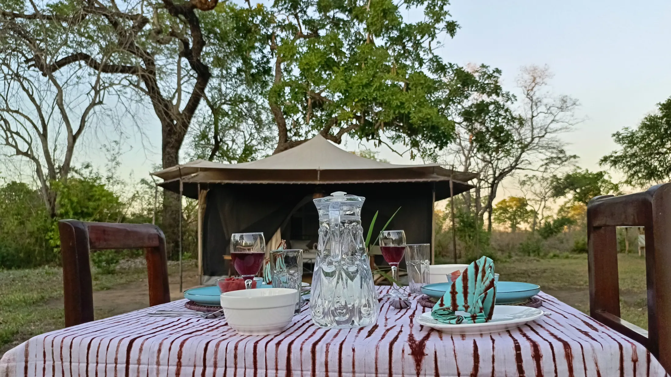 Safari dining table set in front of a Nje Bush Camp tent
