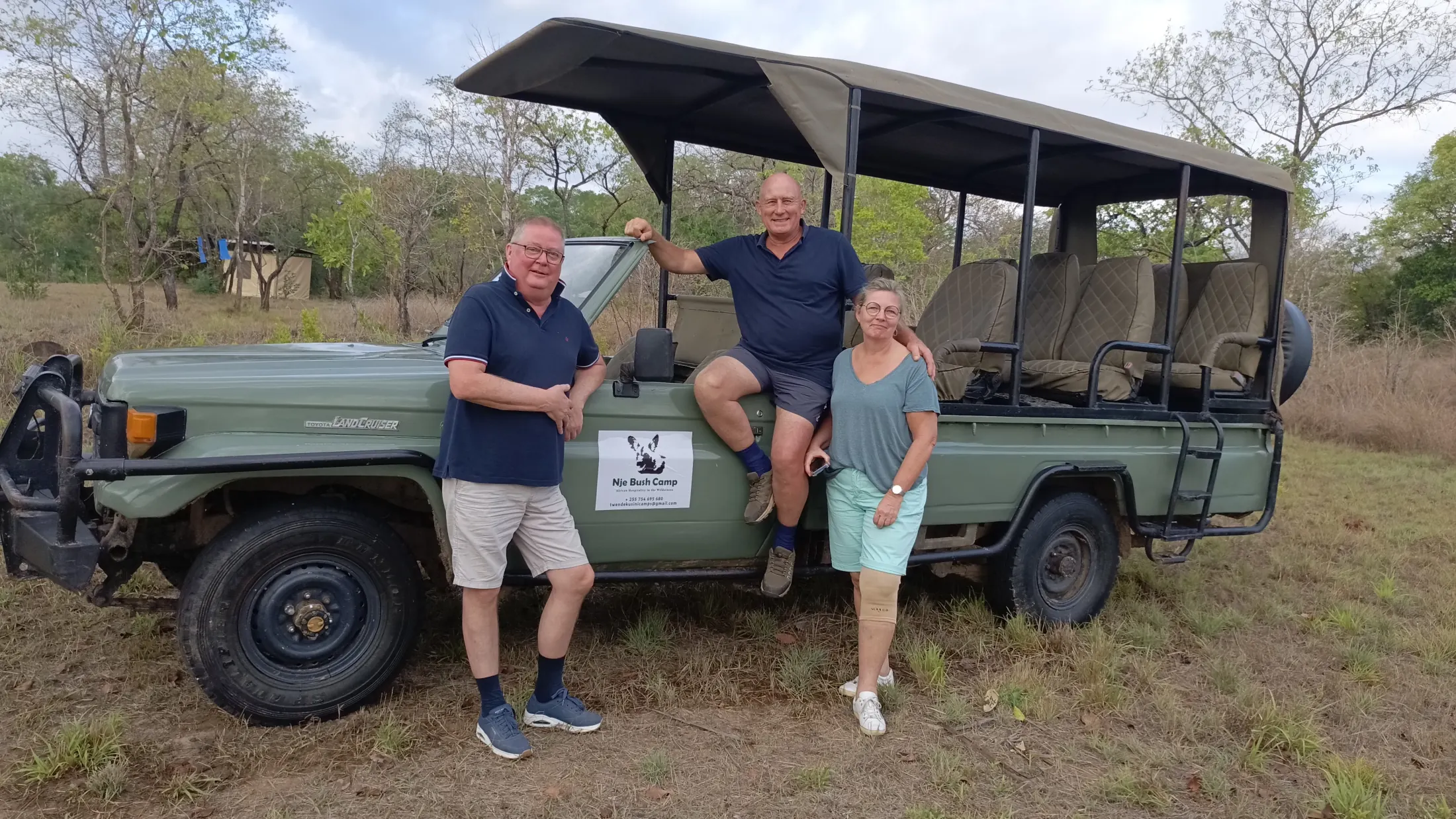 Guests beside a Nje Bush Camp safari vehicle