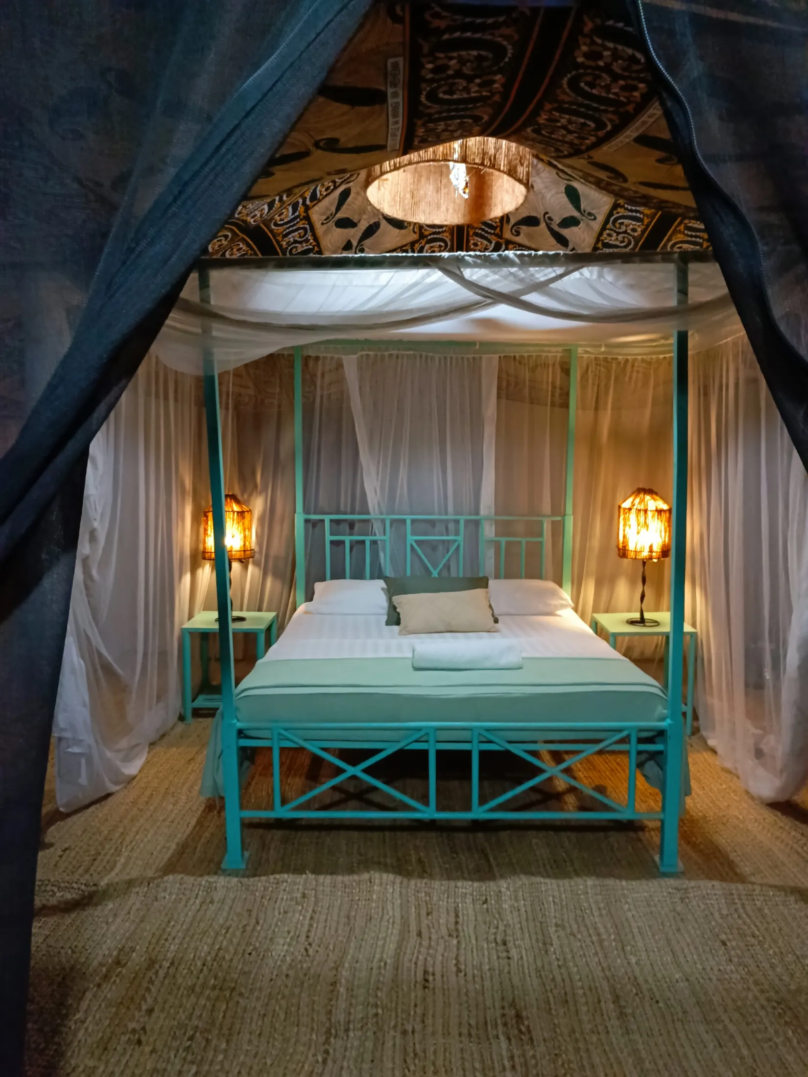 Interior of a Nje Bush Camp tent with a mosquito-netted bed