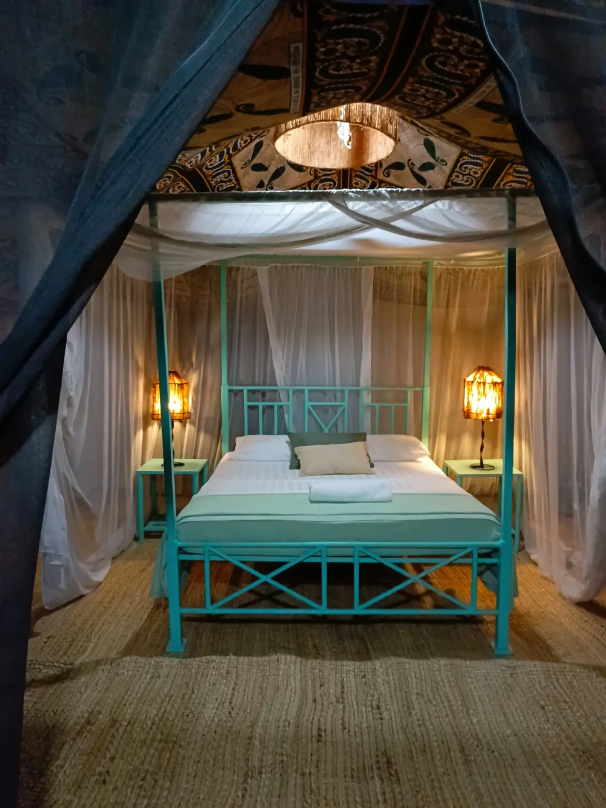 Interior of a Nje Bush Camp tent with a mosquito-netted bed